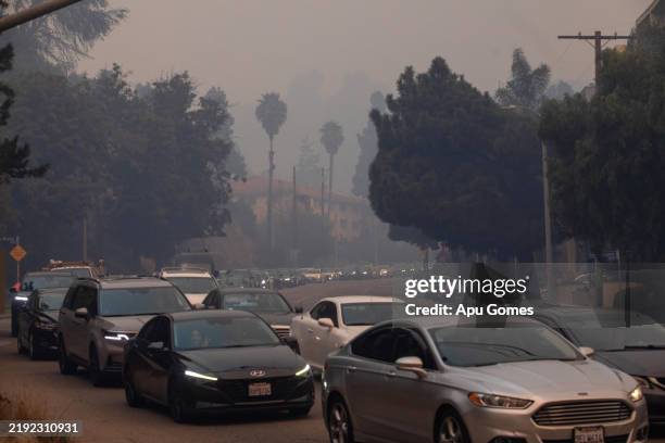 People drive cars on Sunset Boulevard as they evacuate from the Palisades Fire on January 7, 2025 in the Pacific Palisades neighborhood of Los...