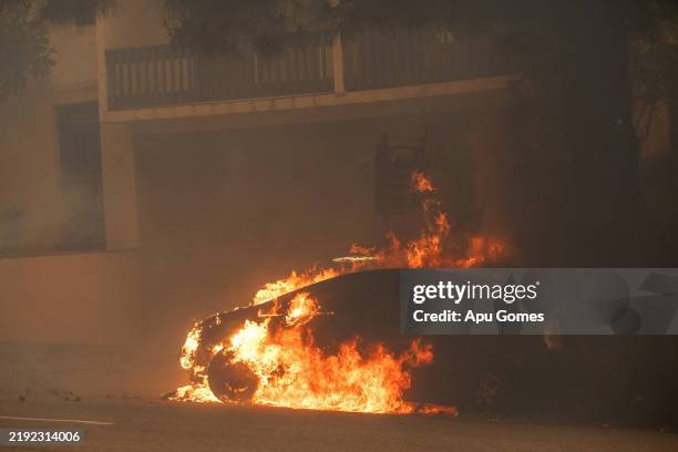 Car burns on Sunset Boulevard as the Palisades Fire burns amid a powerful windstorm on January 7, 2025 in the Pacific Palisades neighborhood of Los...