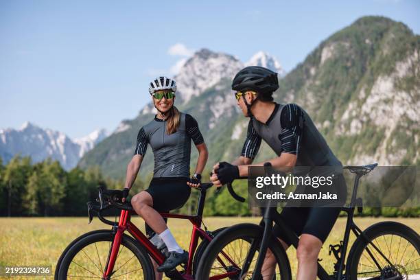 cheerful caucasian friends having a conversation during their bike ride break in the alpes - bicicleta de corrida imagens e fotografias de stock