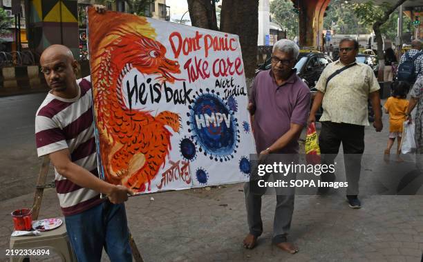 Teachers from Gurukul school of art carry back a poster painted to create awareness and remain alert about the outbreak of Human metapneumovirus on...