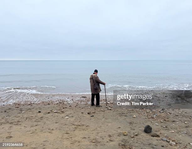 senior man on a beach - seniors active lifestyle winter stock pictures, royalty-free photos & images
