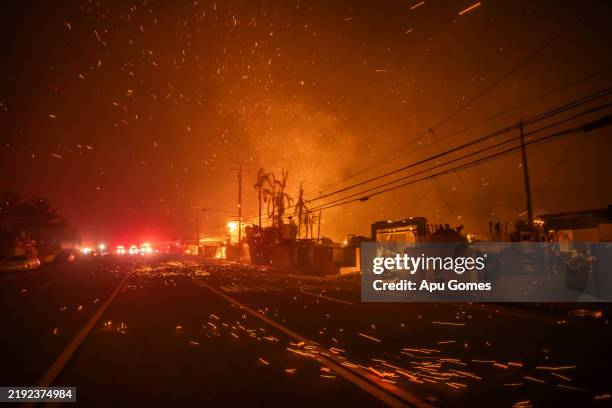Strong winds blow embers as the Palisades Fire burns homes on the Pacific Coast Highway amid a powerful windstorm on January 8, 2025 in Los Angeles,...