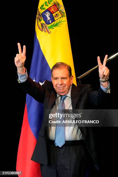 Venezuelan opposition leader Edmundo Gonzalez Urrutia raises two fingers in a 'V' meaning 'Victory' as he arrives at the Act of Reaffirmation of...