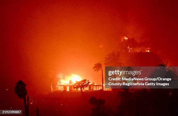 January 08: Homes burn above Pacific Coast Highway near Will Rodgers State Beach during the Palisades Fire on Wednesday, January 8 in Pacific...