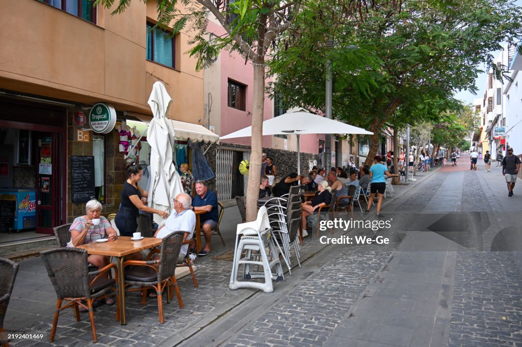 Tourists and locals sit in street cafés in Calle Ntra. Sra. del Carmen in Pájara / Morro Jable, Fuerteventura., Fuerteventura.