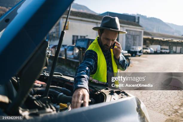 man uses mobile phone near vehicle break down - inconvenience stock pictures, royalty-free photos & images