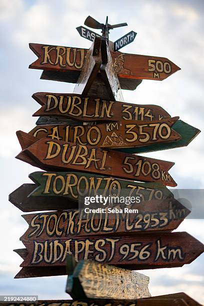 wooden signpost showing distances to various cities around the world - kilometre stock pictures, royalty-free photos & images