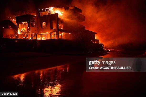 Beach house is engulfed in flames as the Palisades Fire burns along Pacific Coast Highway in Malibu, California, on January 8, 2025. At least five...