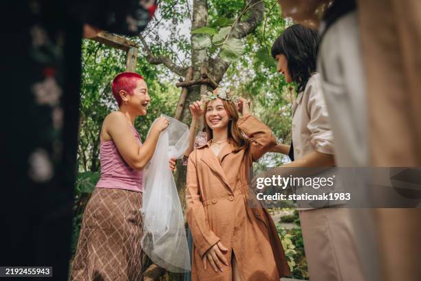 a group of adorable lgbtq friends smile and take photos together in a surprise marriage proposal. - ring ceremony stock pictures, royalty-free photos & images