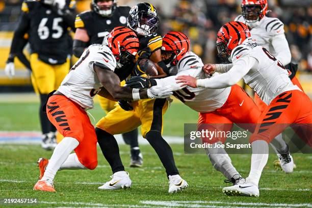 Najee Harris of the Pittsburgh Steelers is tackled by Germaine Pratt of the Cincinnati Bengals and Kris Jenkins Jr. #90 of the Cincinnati Bengals in...