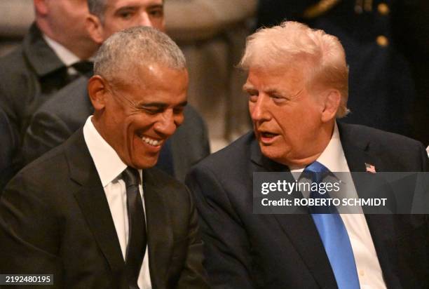 Former US President Barack Obama speaks with President-elect Donald Trump before the State Funeral Service for former US President Jimmy Carter at...