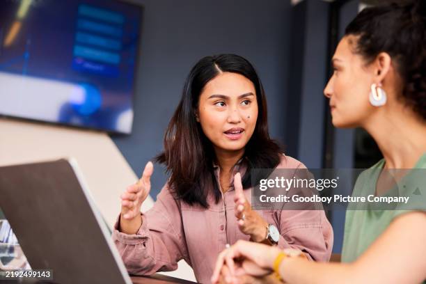 businesswoman with laptop explaining and gesturing to colleague - kommunikationssätt bildbanksfoton och bilder