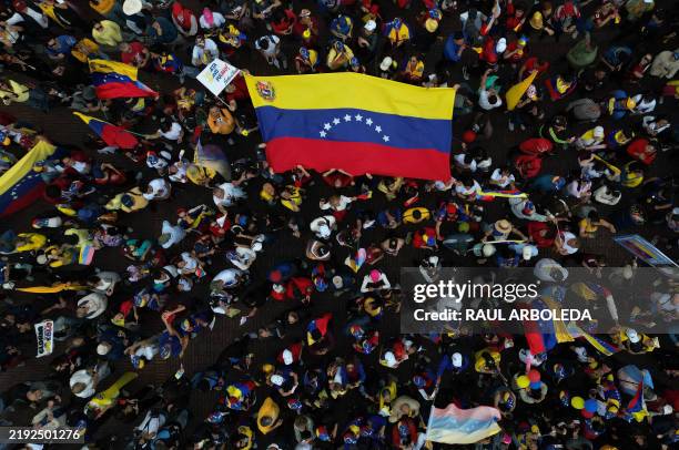 This aerial view shows Venezuelan people resident in the country unfold a Venezuelan flag during a demonstration called by the opposition on the eve...