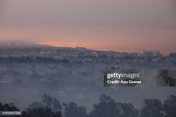 Wildfire smoke from the Palisades Fire hangs over Santa Monica seen from Will Rogers State Park on January 9, 2025 in the Pacific Palisades...