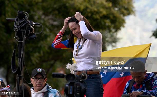 Venezuelan opposition leader Maria Corina Machado puts on a rosary during a protest called by the opposition on the eve of the presidential...