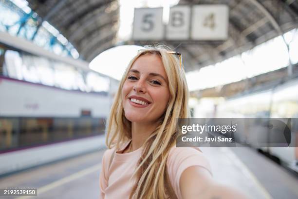 turista sorridente che si fa un selfie alla stazione ferroviaria - stazione foto e immagini stock