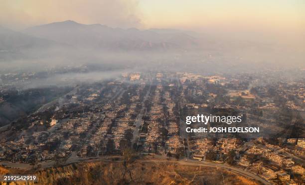 In this aerial view taken from a helicopter, burned homes are seen from above during the Palisades fire near the Pacific Palisades neighborhood of...