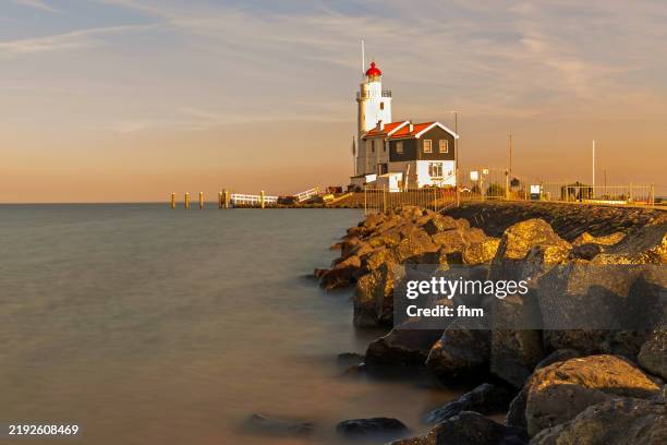 travel destination: lighthouse paard van marken at sunset - ijsselmeer stockfoto's en -beelden