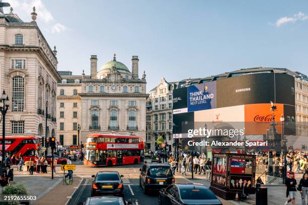 piccadilly circus with crowds of people, advertising screens and red double-decker buses, london, england, uk - piccadilly circus city of westminster stockfoto's en -beelden