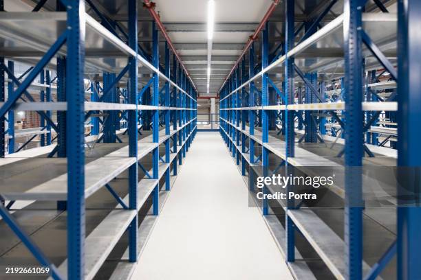 grand entrepôt de distribution avec racks vides - équipement-industriel photos et images de collection