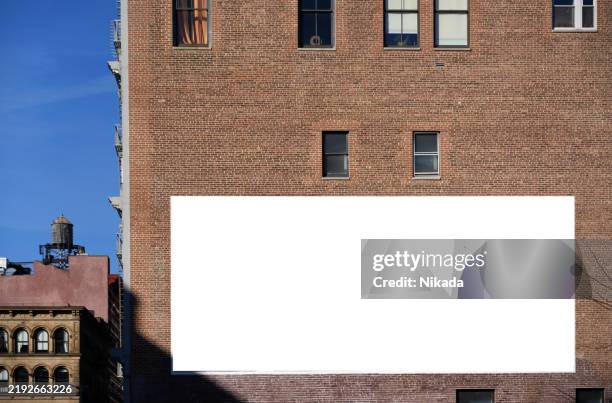 blank urban billboard on brick wall in new york city downtown area - reclamebord activiteit stockfoto's en -beelden