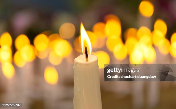 close-up of candle burning in mourning - muerte fotografías e imágenes de stock