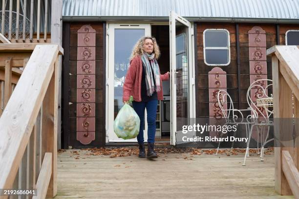 a mature woman taking out the garbage for recycling - removing stock pictures, royalty-free photos & images