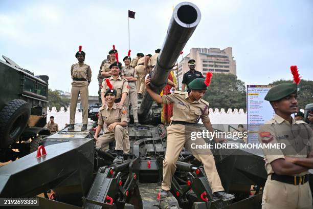National Cadet Corps personnel climb atop an army tank during the 'Know Your Army Exhibition' held ahead the upcoming 77th Indian Army Day, at...