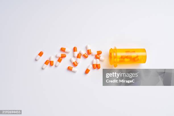 many capsules spilled from a pill bottle - pil stockfoto's en -beelden
