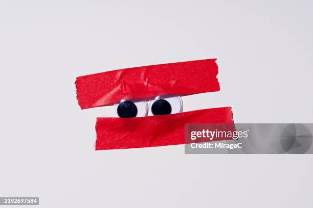 googly eyes covered by red tape, bureaucracy concept - bureaucracy stock pictures, royalty-free photos & images
