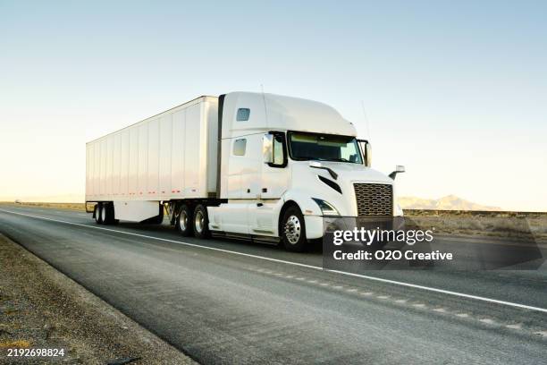 long haul semi truck on a western usa interstate highway - vrachtwagen met oplegger stockfoto's en -beelden