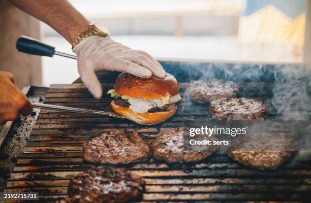 grilling burgers with tongs and buns - i was turning into a vegetable stock pictures, royalty-free photos & images
