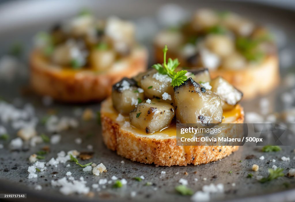 A close-up shot of a canape with chunks of salted herring and onions