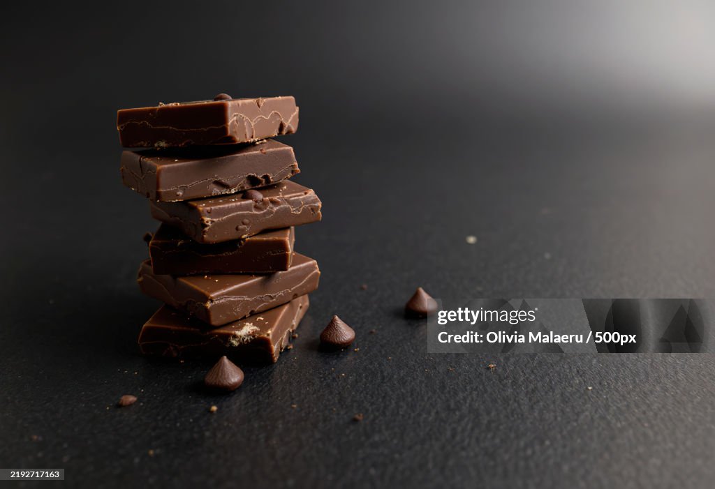 A stack of chocolate pieces on a black background