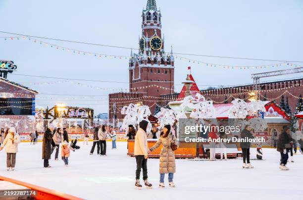 ice skating rink on red square in moscow christmas market with festive decor and lights. - red square stock pictures, royalty-free photos & images