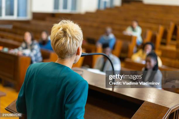 over the shoulder view of a university tutor teaching her class - achterhoofd stockfoto's en -beelden