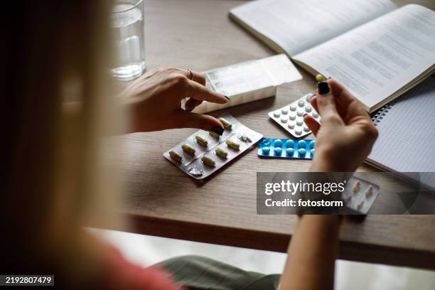 giovane donna che prende le sue medicine - farmaco foto e immagini stock