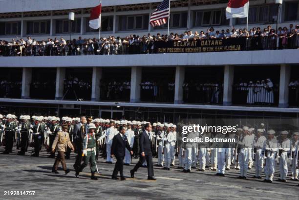 President Richard Nixon and Indonesian President Suharto reviewing an honour guard at Djakarta Airport, Indonesia, July 27th 1969. A welcome banner...