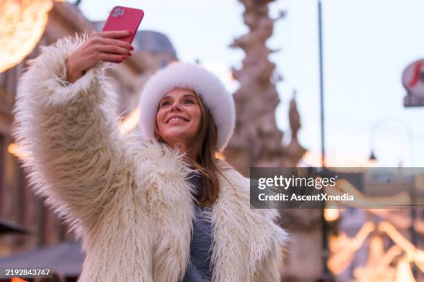 portrait de femme à la mode à l’aide d’un téléphone portable - manteau de fourrure photos et images de collection