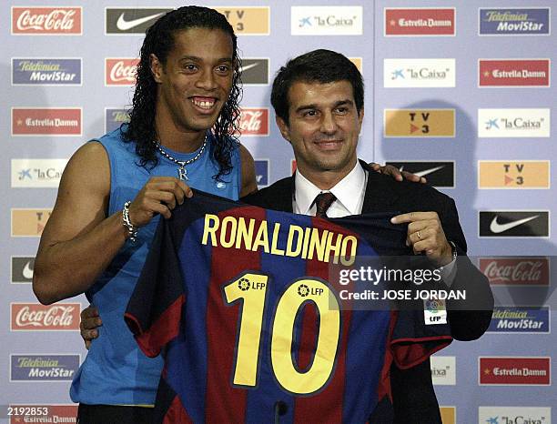 Barcelona's new Brazilian soccer star Ronaldinho and Barcelona newly-elected president Joan Laporta hold Ronaldinho 's jersey during his official...