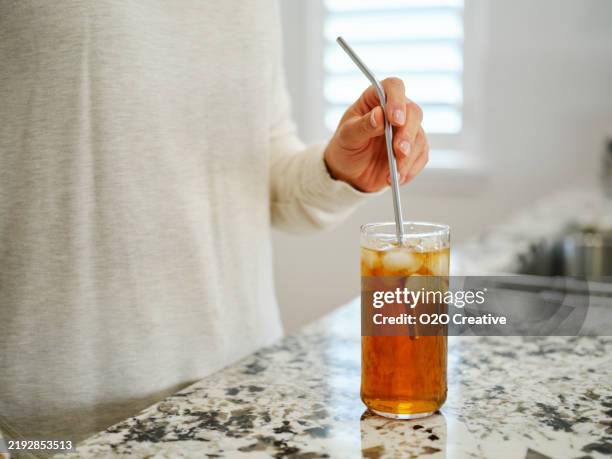 woman putting a resuable drinking straw in a beverage - ice tea stock pictures, royalty-free photos & images