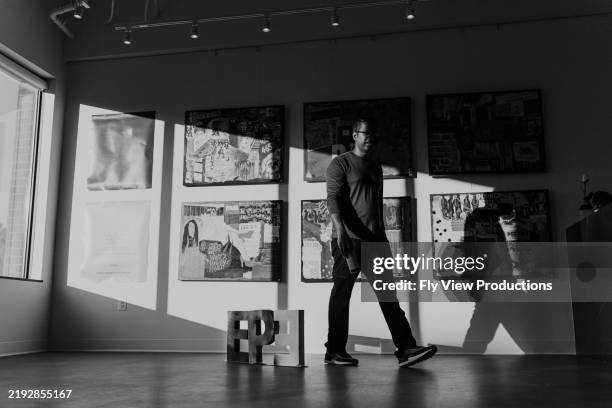 man walking past art installation in medical office waiting room - kunstatelier stockfoto's en -beelden