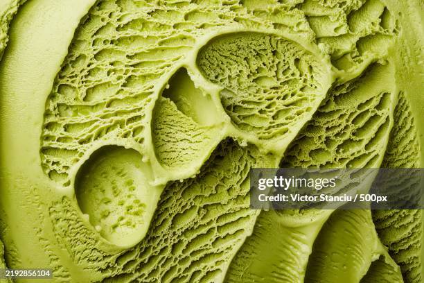 a close-up photo of a textured surface with a vibrant green shade,resembling a scoop of green ice cream - gelato stock-fotos und bilder
