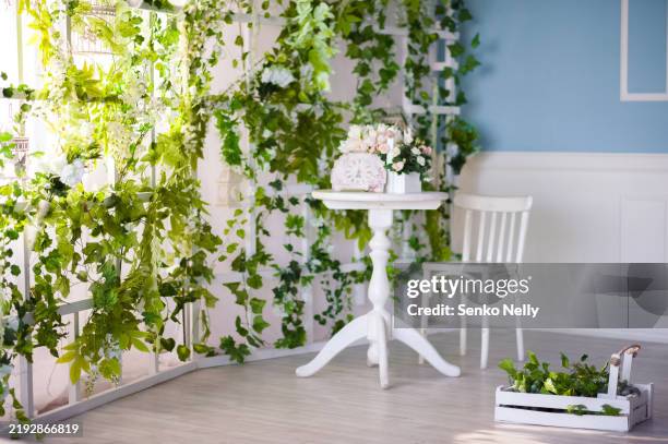 bright vintage interior with green ivy and floral decorations - spalier stock-fotos und bilder