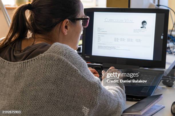 woman updating her cv/resume online. freelancer job search - cv bildbanksfoton och bilder