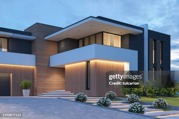 zeitgenössische villa mit atemberaubender stein- und holzpaneelen, fassade und vorgarten bei sonnenuntergang - gebäudeteil stock-fotos und bilder