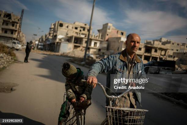 Man rides a bike as people return to their homes at Jouret Ash-Shayyah and Al-Khalidiyah neighbourhoods that were heavily bombed by the forces of the...