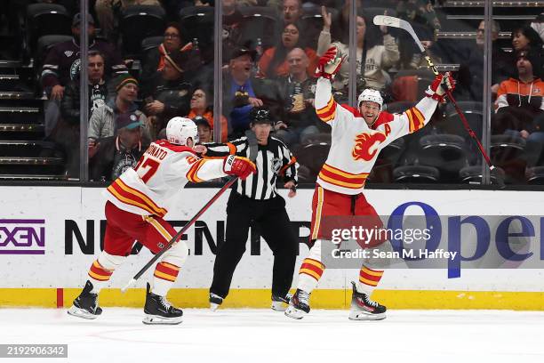 Matt Coronato congratulates Jonathan Huberdeau of the Calgary Flames after his goal during overtime of a game against the Anaheim Ducks at Honda...