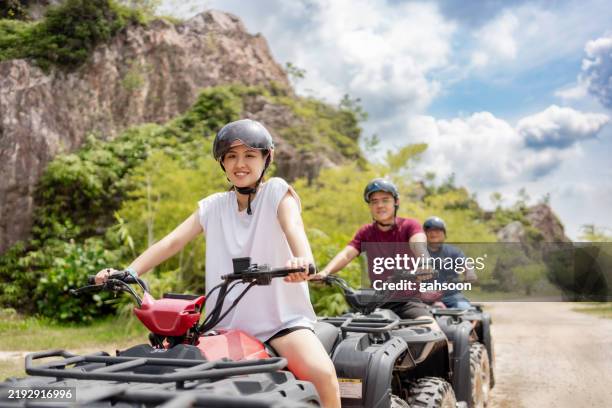 pareja montando cuatrimoto al aire libre - vehículo de todo terreno fotografías e imágenes de stock