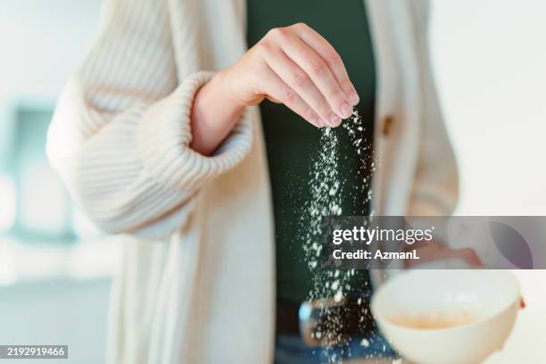 mixed race teenage girl baking with flour at home - sprinkling stock pictures, royalty-free photos & images